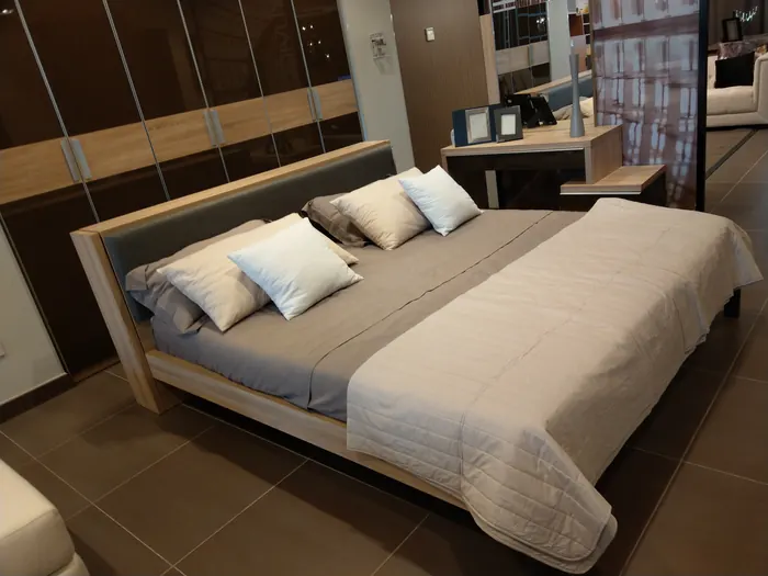 Lit capitonné en tissu gris avec coussins blancs