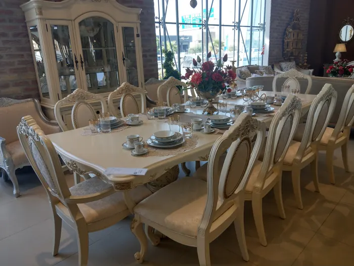 Table classique crème, chaises à dossier ovale et vitrine