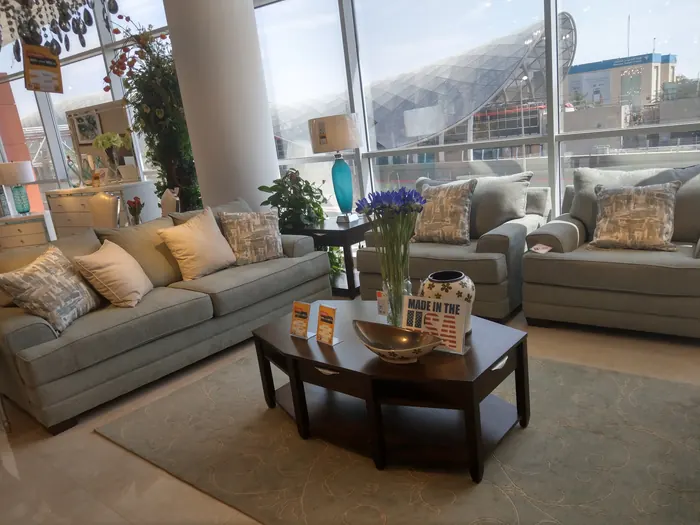 Salon gris-bleu, coussins ocre et table basse ovale