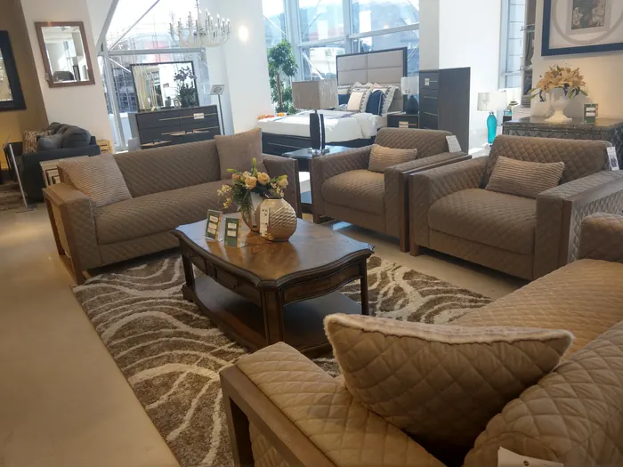 Canapé et fauteuils matelassés taupe sur tapis ondulé